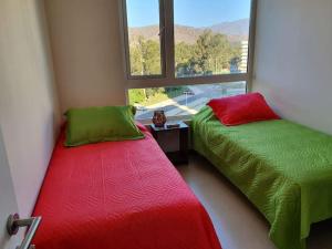 2 Betten in einem Zimmer mit Fenster in der Unterkunft Dpto 2D1B en Papudo Laguna, Piso 8, Edf Flemenco con vista al mar in Papudo