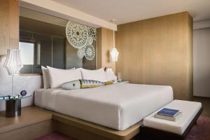 a bedroom with a large white bed and a table at W Algarve in Albufeira