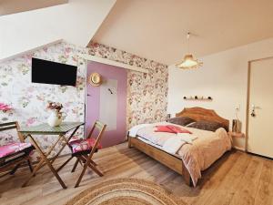 Schlafzimmer mit einem Bett und einem Tisch in der Unterkunft La Tour Des Quatre Chemins in Gramat