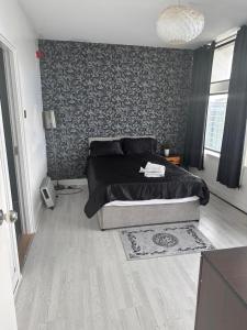 1 dormitorio con 1 cama con pared negra y gris en Stunning Two bedroom Apartment, Amazing City Views en Mánchester