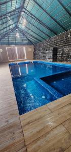 a large indoor swimming pool with blue water at Sunrise Chalet شالية الشروق الجبل الاخضر in Duwaykhīlah