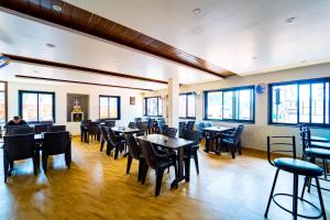 una sala da pranzo con tavoli, sedie e finestre di Darsy Residency ad Agonda
