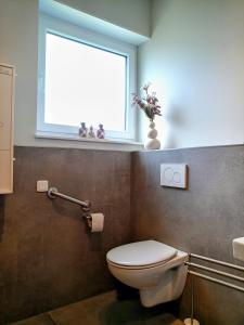La salle de bains est pourvue de toilettes et d'une fenêtre. dans l'établissement Gäste und Messezimmer Adelheidsdorf, à Adelheidsdorf