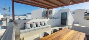 a balcony with a wooden table and chairs at Sabbia Suites Casa Brisa in Famara