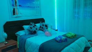 1 dormitorio azul con 1 cama con luces azules en Disfruta de un barrio tranquilo, en Alcalá de Guadaira
