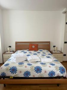 a bedroom with a bed with a white and blue blanket at Casa Romy in Rovere della Luna