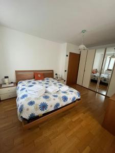 a bedroom with a bed with a blue and white comforter at Casa Romy in Rovere della Luna