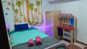 a bedroom with a bed with pink slippers on it at Disfruta de un barrio tranquilo in Alcalá de Guadaira