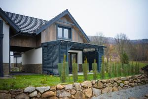 a house with a stone wall in front of it at Domek na szlaku in Szklarska Poręba