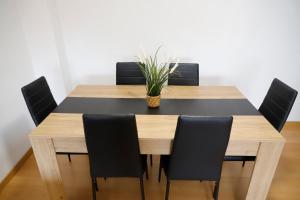 奧維多的住宿－ACOGEDOR Y LUMiNOSO，餐桌,配有黑色椅子和植物