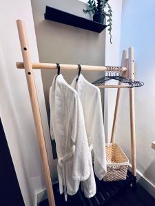 a wooden towel rack with white towels hanging on it at Luxury self-contained suite. in Cardiff