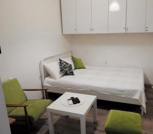 una piccola camera con un letto e due sedie e un tavolo di Vukov spomenik a Belgrado