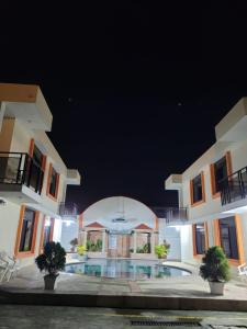 a large building with a swimming pool at night at El Sol Dorado in Tonsupa