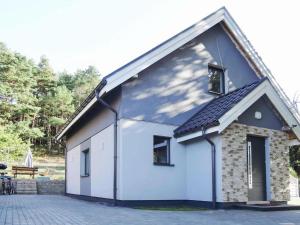 biały budynek ze skośnym dachem w obiekcie Holiday Home in Karnocicie by Szczecin Lagoon w mieście Dargobądz