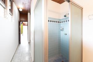 a bathroom with a shower with blue tiles at Volcano Hostal y Restaurante in San Salvador