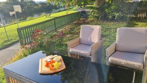 two chairs and a table with a tray of fruit on it at Haus an der Weser in Oedelsheim