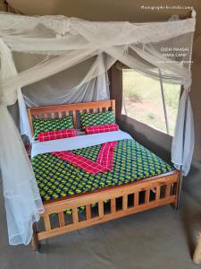 a wooden bed in a canopy in a room at Oseki Maasai Mara Camp in Narok