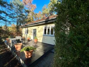 ein Haus mit einer Terrasse mit Topfpflanzen darauf in der Unterkunft Ferienhaus im Grünen mit Kamin in Oranienburg