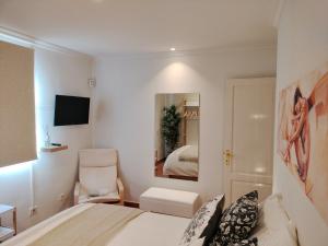 una camera da letto bianca con un letto e una sedia di Casa Luz a Costa Calma