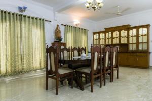 comedor con mesa de madera y sillas en Kichu’s house, en Ernakulam