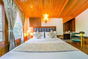 a bedroom with a bed and a wooden ceiling at Singhs BnB by Lazy Getaways in Shimla