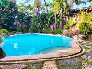 - une piscine dans un complexe avec des palmiers dans l'établissement Nathan's Staycation, à Manille