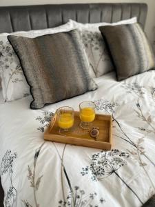 dois copos de sumo de laranja numa bandeja numa cama em Woodside-Filey em Filey