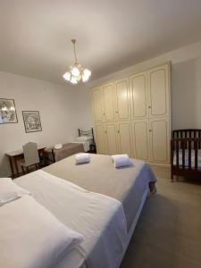 1 dormitorio con 2 camas y lámpara de araña en La tenuta di Eva en Pisa