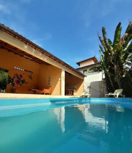 uma grande piscina em frente a uma casa em Le Marchand de Sable- Suites e apartamento em Búzios