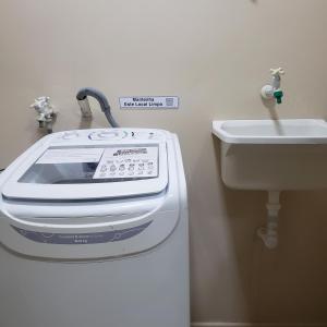 a washing machine and a sink in a bathroom at Hospedagem Costa BNU - PLUS in Blumenau