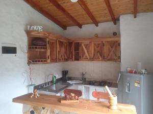a kitchen with wooden cabinets and a sink and a refrigerator at alto palmas 2.0 in Medellín