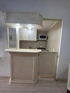 cocina con armarios blancos y encimera en Studio 1403 com vaga de garagem., en São Paulo