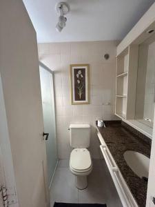 a white bathroom with a toilet and a sink at Studio 1403 com vaga de garagem. in Sao Paulo