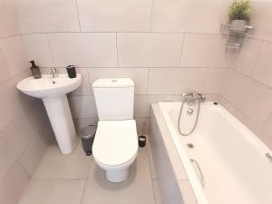 a white bathroom with a toilet and a sink at White City Gardens, Empangeni, Ngwelezana in Empangeni