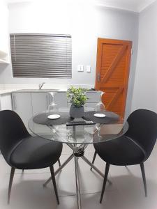 a dining room with a glass table and two chairs at White City Gardens, Empangeni, Ngwelezana in Empangeni