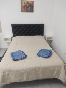 Una cama con dos toallas azules encima. en Monoambiente en Buenos Aires