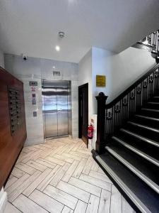 a hallway with a metal door and stairs in a building at Modern Studio Apartment - Prime Location by BOLD Apartments in Liverpool