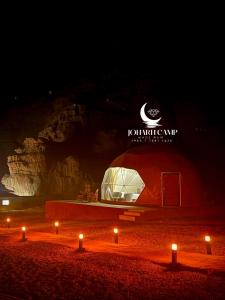 a large tent in the middle of a beach at night at RUM JOHARH lUXURY CAMP in Wadi Rum