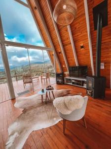 a living room with a large animal skin rug at Casa Di Legno Cabana com Spa, Ofurô e Vista para as Montanhas in Urubici +13 photos
