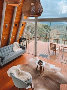 una sala de estar con un sofá y una mesa en Casa Di Legno Cabana incrível com vista para as montanhas, en Urubici