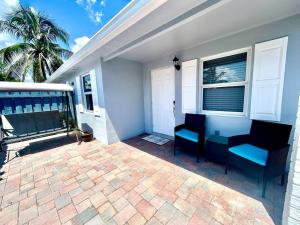 a patio with blue chairs and a house at Gorgeous & Convenient Apartment Near Airport in West Palm Beach
