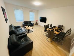 a living room with black leather furniture and a table at City Apartment - 9 Bedrooms - 22 Beds - WiFi - Kitchen in Paderborn