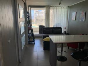 sala de estar con mesa y sofá en Departamento La Serena Laguna del Mar en La Serena