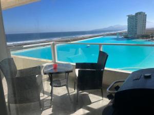 ラ・セレナにあるDepartamento La Serena Laguna del Marのバルコニー(テーブル、椅子付)、スイミングプールが備わります。 +5枚の写真