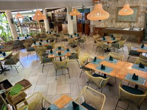 un restaurant vide avec des tables et des chaises en bois dans l'établissement The Falls at Manuel Antonio, à Manuel Antonio