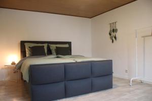 a bedroom with a large bed with a blue headboard at Ferienhäuschen Brohlbachtal in Gamlen +8 photos
