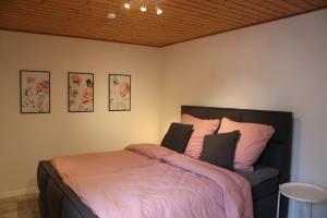a bedroom with a large bed with pink pillows at Ferienhäuschen Brohlbachtal in Gamlen