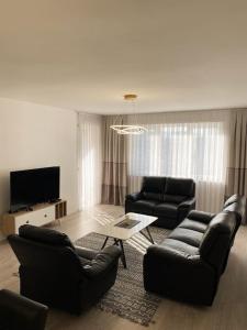 a living room with two couches and a tv at City Center Apartment in Ferizaj