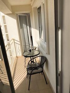 a balcony with a table and a chair on a balcony at City Center Apartment in Ferizaj