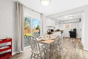 una cucina e una sala da pranzo con tavolo e sedie di New! Warm & Cozy 3BR w/ Hot Tub, Firepit & BBQ! a Mount Clemens